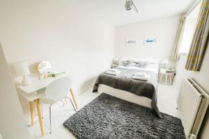 a bedroom with a bed and a desk and a rug at Charming & Stylish 2-Bed House - 20 min Walk to Centre in Bath