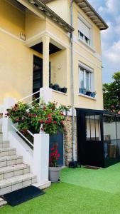 een huis met een trap met bloemen erop bij Charmant logement parking gratuit, gare proximité in Sevran