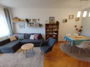 uma sala de estar com um sofá azul e uma mesa em Greenview Apartment em Budapeste