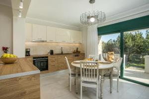 a kitchen and dining room with a table and chairs at Beach Front Villa Rhodes Seashell in Gennadi