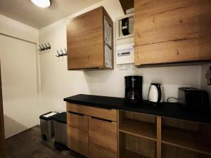 uma cozinha com bancada e armários de madeira em Résidence Lac Du Lou - Studio pour 4 Personnes 074 em Les Menuires