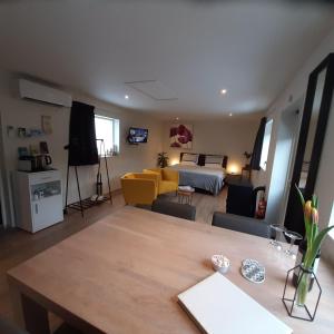 a living room with a dining table and a bedroom at Bed & Breakfast Stiens (nabij Leeuwarden) in Stiens