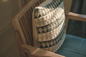 a crocheted blanket on the back of a wooden chair at HOMIE TERRACE Funakata in Tateyama