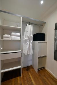 a closet with white shelves and white towels at L'attrape coeurs in Mantilly