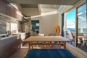a kitchen with a wooden table and a large window at HOMIE TERRACE Funakata in Tateyama