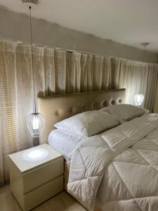 una camera con letto bianco e comodino di Town Square Apartment Tirana 4 a Tirana