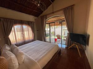 een slaapkamer met een bed en een groot raam bij Red Sands Pool Villa in Phan Thiet