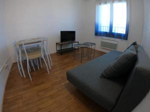 uma sala de estar com um sofá e uma mesa em 40m² totalement rénovés belle vue dégagée (001) em Villeneuve-Saint-Georges