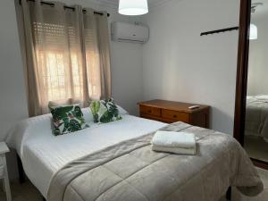 Dormitorio pequeño con cama y espejo en Apartamento Familiar En Barrio Reina Victoria, en Huelva