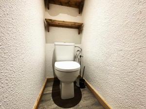 ein Bad mit einem weißen WC in einem Zimmer in der Unterkunft Résidence Lac Du Lou - Studio pour 4 Personnes 214 in Les Menuires