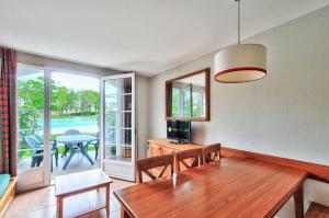 uma sala de estar com uma mesa de jantar e vista para um pátio em La résidence du Lac - maeva Home - Maison 3 Pièces 6 Personnes - Confort 764 em Monflanquin