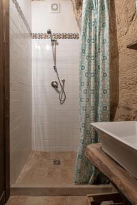 a bathroom with a shower curtain and a sink at Case degli Avi 2, antico abitare in grotta in Modica