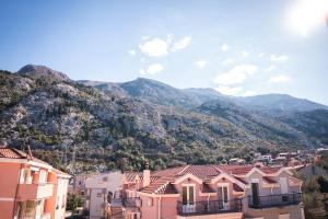 a view of a town with mountains in the background at Marinero Apartments in Kotor