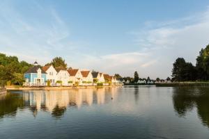 eine Reihe von Häusern am Ufer eines Sees in der Unterkunft Résidence Belle Dune - maeva Home - Appartement 2 pièces 4 personnes - Sélection MAE-9294 in Fort-Mahon-Plage