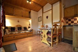 een keuken met een bank en een tafel in een kamer bij Résidence Carlines Ii - Studio pour 4 Personnes 354 in Les Menuires