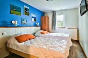 two beds in a bedroom with blue walls at Résidence Belle Dune - maeva Home - Appartement 2 pièces 4 personnes - Sélection MAE-9334 in Fort-Mahon-Plage