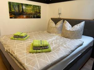 ein Bett mit grünen und weißen Kissen darauf in der Unterkunft SEA Office - Modernes Ferienhaus mit tollem Seeblick in Kirchheim