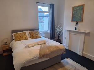 - une chambre avec un lit avec deux oreillers et une cheminée dans l'établissement Anfield Abbey House, à Liverpool