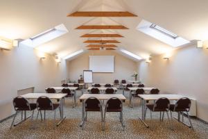 uma sala de aula com mesas e cadeiras num quarto com clarabóias em City Hotels Algirdas em Vilnius