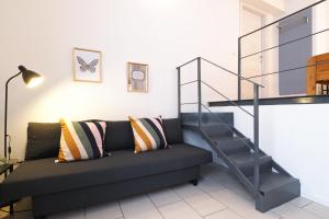 - un salon avec un canapé et un escalier dans l'établissement PrimoPiano - Acerenza Flats, à Milan