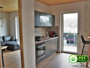 a kitchen with stainless steel appliances and a living room at Ferienwohnungen am Schlossberg in Riedenburg +35 photos