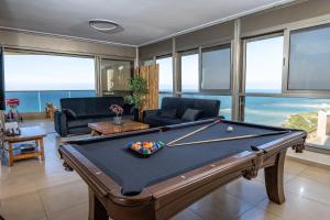 una mesa de billar en la sala de estar con vistas en Shamyam -שמיים- דירות מהממות על חוף הים עם ג'קוזי פרטי ובריכה במתחם en Netanya