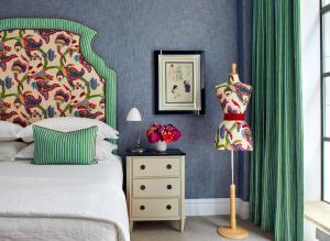 a bedroom with a bed with green curtains and a dresser at The Whitby Hotel in New York