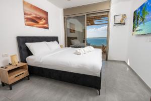 1 dormitorio con 1 cama y vistas al océano en Shamyam -שמיים- דירות מהממות על חוף הים עם ג'קוזי פרטי ובריכה במתחם en Netanya