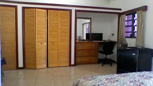 a bedroom with a bed and a dresser and a desk at Seaview Apartments in Cudjoe Head