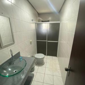 uma casa de banho com um lavatório, um WC e um chuveiro em Apartamento Principado em Torres
