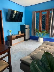 a blue living room with a couch and a tv at Blue Sky Home stay 