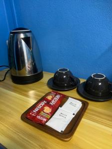 a table with a coffee maker and a tray with a book at Blue Sky Home stay 