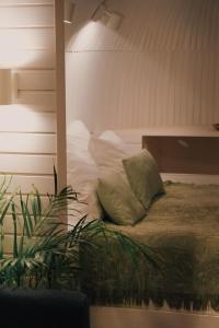 a bed with pillows and a plant in a room at Iglupark in Tallinn