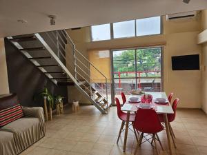 a living room with a table and chairs and a staircase at Monoambiente en Duplex Velez Sarsfield in Buenos Aires