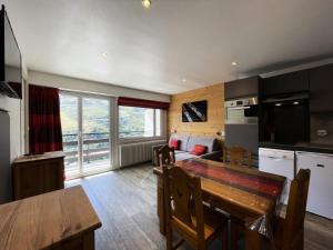 a kitchen and living room with a table and a couch at Résidence Oisans - Studio pour 4 Personnes 514 in Les Menuires