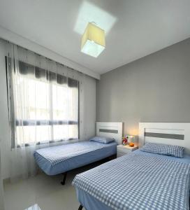 En eller flere senge i et værelse på Elisa Bay apartment Mil Palmeras