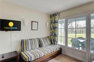 un salon avec un canapé et un balcon dans l'établissement Résidence Les Belles Rives - maeva Home - Appartement 2 Pièces 5 Personnes - Confort MAE-5614, à Argentat