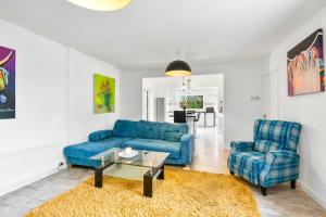 a living room with a blue couch and two chairs at Exmoor Close in North Hykeham