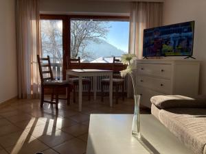 ein Wohnzimmer mit einem Esstisch, einem Tisch und Stühlen in der Unterkunft Ferienwohnung Aigisblick mit Pool und Sauna, direkt am Skihang in Missen-Wilhams
