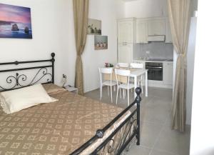 a bedroom with a bed and a kitchen with a table at Appartamenti La Nina & La Nzina in Otranto