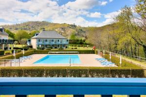 a swimming pool in front of a large house at Résidence Les Belles Rives - maeva Home - Appartement 2 Pièces 5 Personnes - Sélection MAE-2194 in Argentat