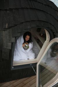 a woman sitting on a bed in a play house at Iglupark in Tallinn