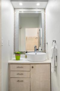 y baño con lavabo blanco y espejo. en Prime Location at Condado Beach Queen Studio - Apt 10, en San Juan