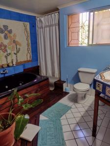 een badkamer met een bad, een toilet en een raam bij JI Home Boutique in Santiago
