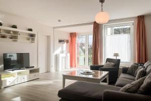 a living room with a couch and a tv at Sünnslag Wohnung 088 in Boltenhagen