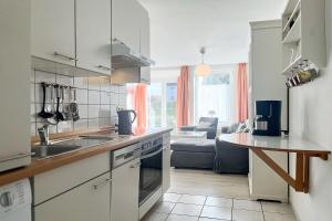 a kitchen with a sink and a stove top oven at Sünnslag Wohnung 088 in Boltenhagen