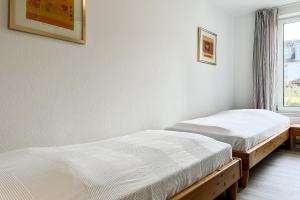 two twin beds in a room with a window at Sünnslag Wohnung 088 in Boltenhagen