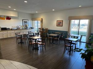 a restaurant with tables and chairs and a kitchen at Quality Inn & Suites Hattiesburg in Hattiesburg