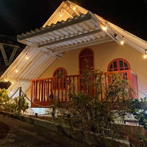 a house with a porch and a deck at night at Cabañita Doña Tina in Los Altos de Cerro Azul