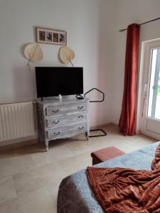 ein Schlafzimmer mit einem Flachbild-TV auf einer Kommode in der Unterkunft Chez Monique et Rémi in Avignon